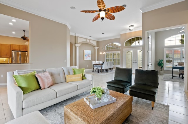 living room featuring ceiling fan, light tile patterned floors, ornamental molding, and ornate columns