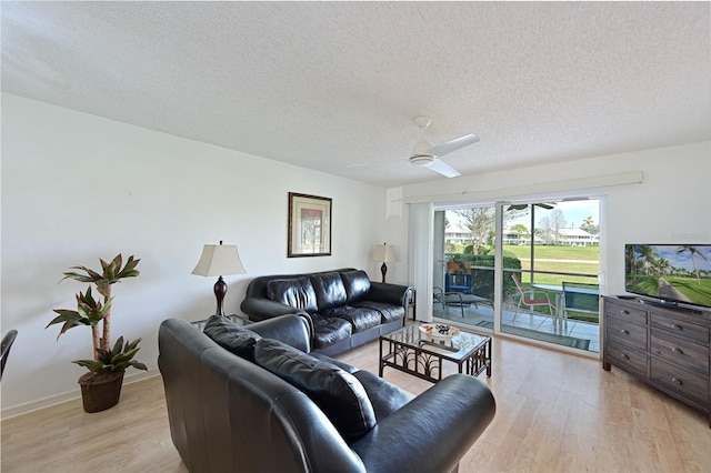 living room with ceiling fan, a textured ceiling, and light hardwood / wood-style flooring