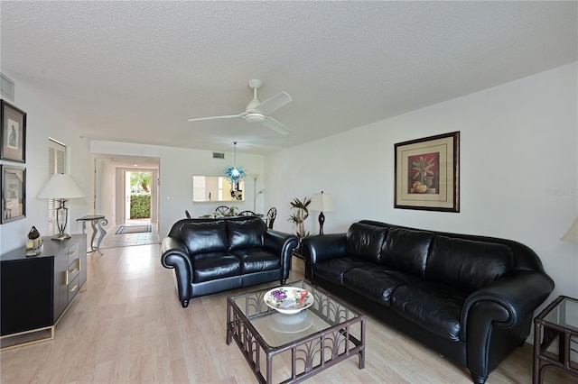 living room featuring a textured ceiling, ceiling fan, and light hardwood / wood-style floors