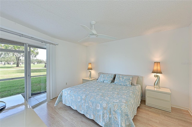 bedroom featuring a textured ceiling, ceiling fan, light hardwood / wood-style flooring, and access to outside