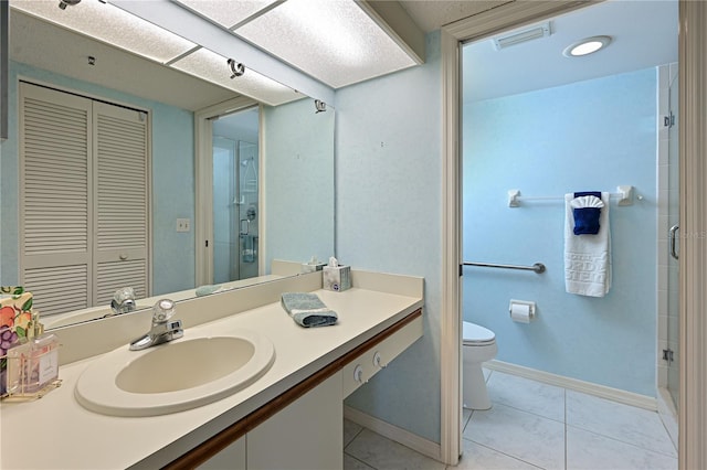 bathroom featuring tile patterned floors, toilet, walk in shower, and vanity