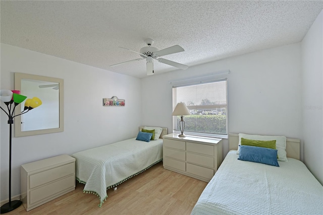 bedroom featuring a textured ceiling, ceiling fan, and light wood-type flooring