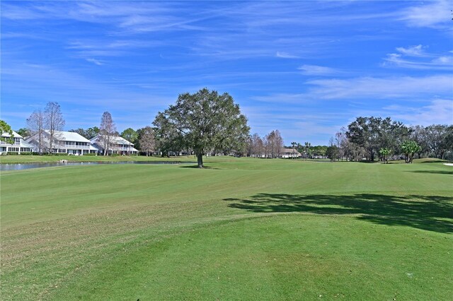 surrounding community with a lawn and a water view