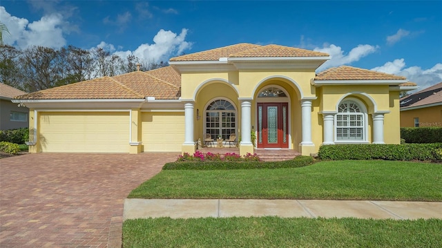 mediterranean / spanish-style home with a garage and a front lawn