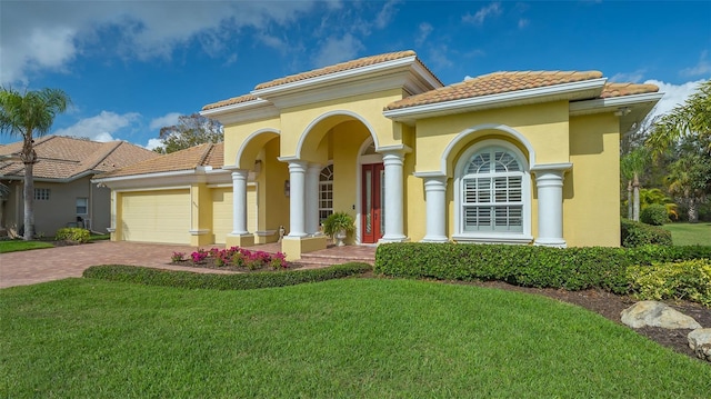 mediterranean / spanish house featuring a garage and a front yard