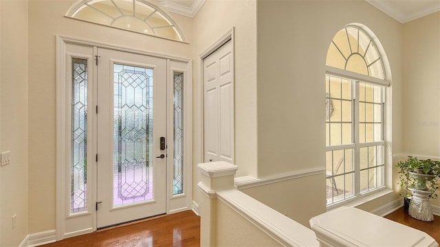 entrance foyer with hardwood / wood-style floors, plenty of natural light, and crown molding