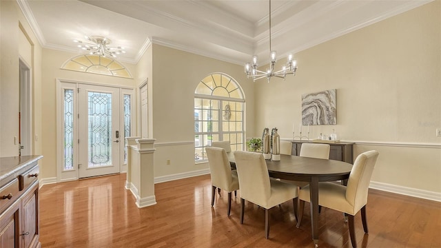 dining room with a chandelier, light hardwood / wood-style floors, and ornamental molding