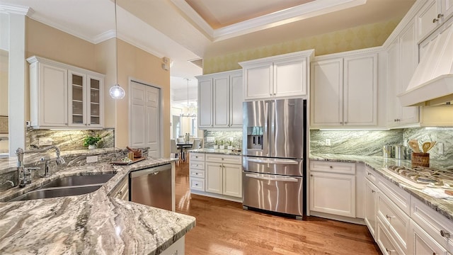 kitchen featuring white cabinets, hanging light fixtures, sink, and appliances with stainless steel finishes