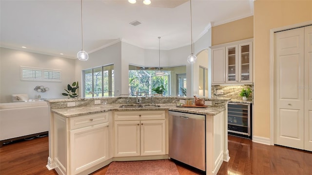 kitchen with light stone countertops, pendant lighting, stainless steel dishwasher, and sink