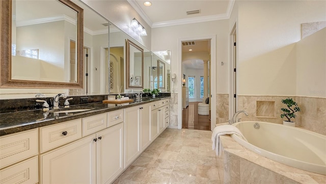 bathroom with a relaxing tiled tub, crown molding, and vanity