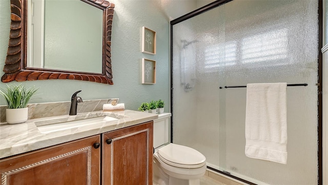 bathroom with vanity, toilet, and a shower with shower door