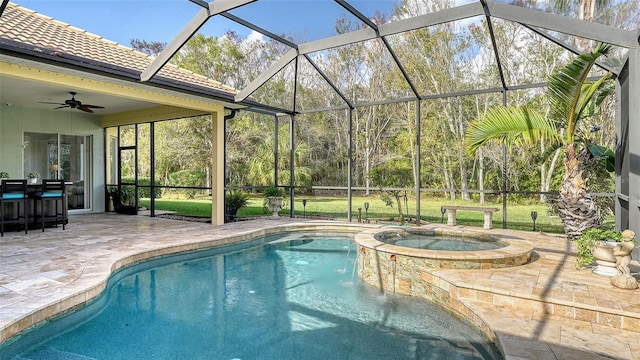 view of swimming pool with an in ground hot tub, a lanai, ceiling fan, and a patio area