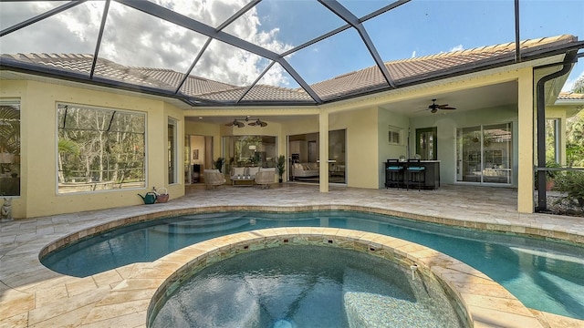 view of swimming pool with outdoor lounge area, ceiling fan, a patio area, and a bar