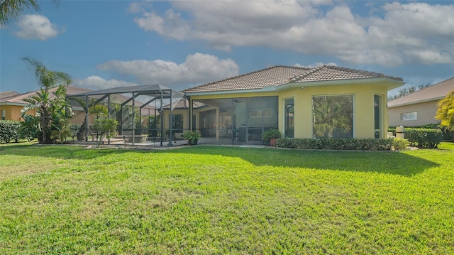 back of house featuring a lawn, glass enclosure, and ceiling fan