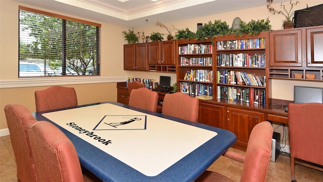 dining room with plenty of natural light, a raised ceiling, light tile patterned floors, and crown molding