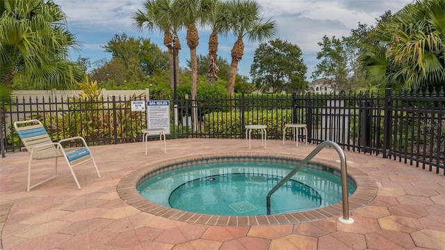 view of pool with a patio area and a hot tub