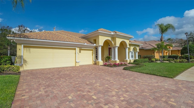 mediterranean / spanish-style house featuring a garage and a front yard