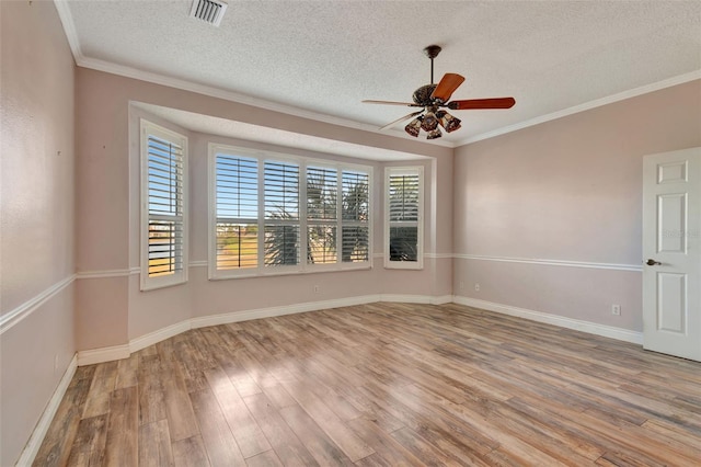 empty room featuring a textured ceiling, light hardwood / wood-style floors, ceiling fan, and ornamental molding