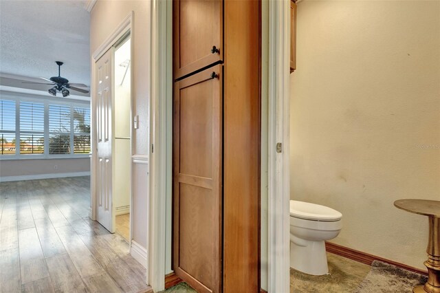 bathroom featuring ceiling fan, hardwood / wood-style floors, a textured ceiling, and toilet