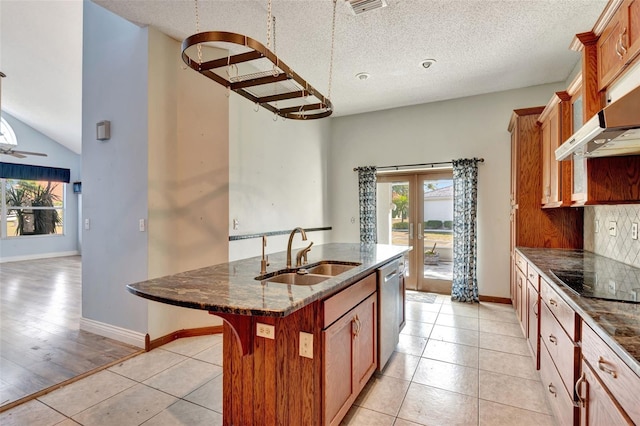 kitchen featuring french doors, a center island with sink, black electric stovetop, sink, and light tile patterned flooring