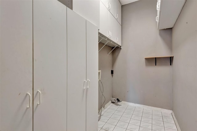 laundry room featuring electric dryer hookup and cabinets