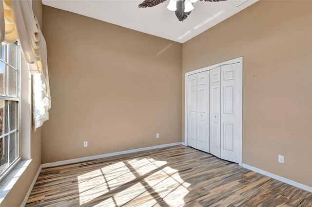 unfurnished bedroom with ceiling fan, a closet, and hardwood / wood-style floors