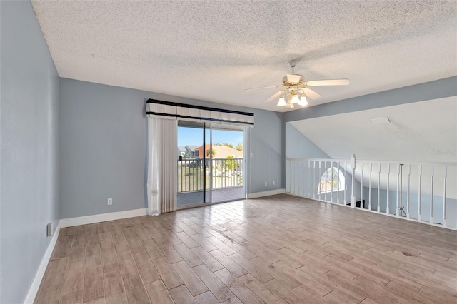 unfurnished room featuring a textured ceiling, ceiling fan, and vaulted ceiling