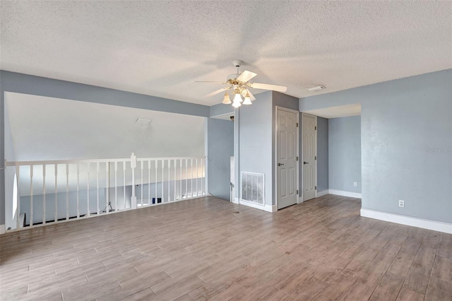 unfurnished room with ceiling fan and a textured ceiling