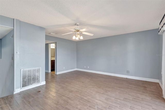 unfurnished room with ceiling fan and a textured ceiling