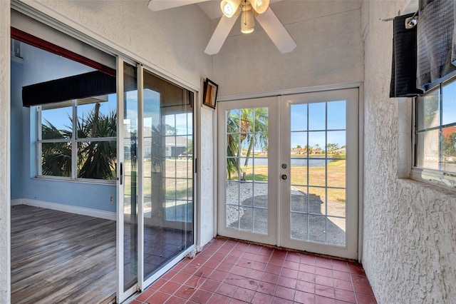 unfurnished sunroom with ceiling fan, a healthy amount of sunlight, and french doors