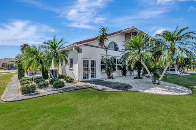 rear view of property with a lawn and french doors