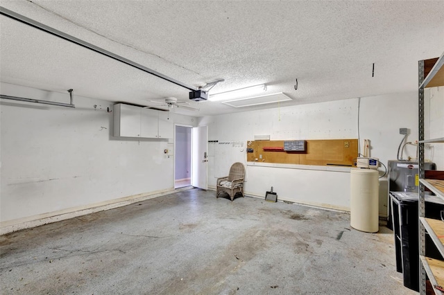 garage with ceiling fan, a garage door opener, and water heater