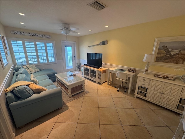 living area featuring light tile patterned flooring, recessed lighting, visible vents, a ceiling fan, and wainscoting