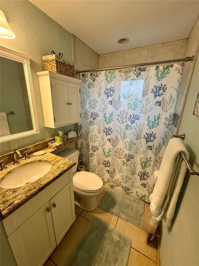 full bathroom with a textured wall, toilet, tile patterned floors, vanity, and a shower with curtain