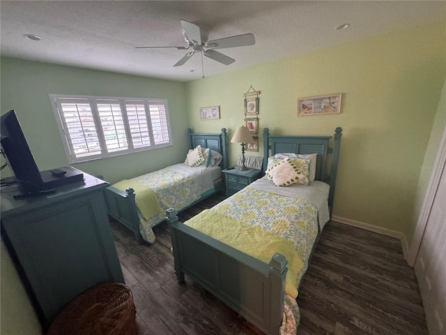 bedroom featuring dark wood-style flooring, ceiling fan, a textured ceiling, and baseboards