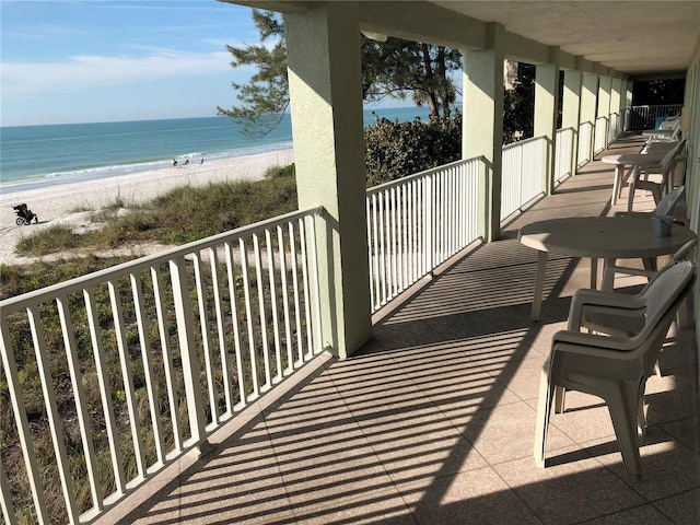 balcony with a water view and a view of the beach