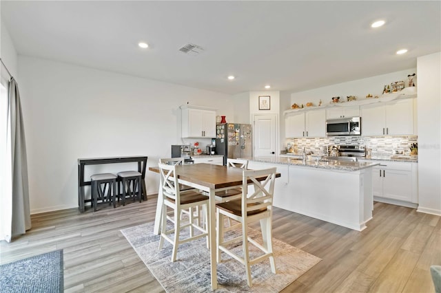 dining space with light hardwood / wood-style flooring