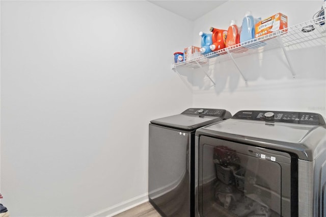 clothes washing area featuring washer and clothes dryer and hardwood / wood-style floors