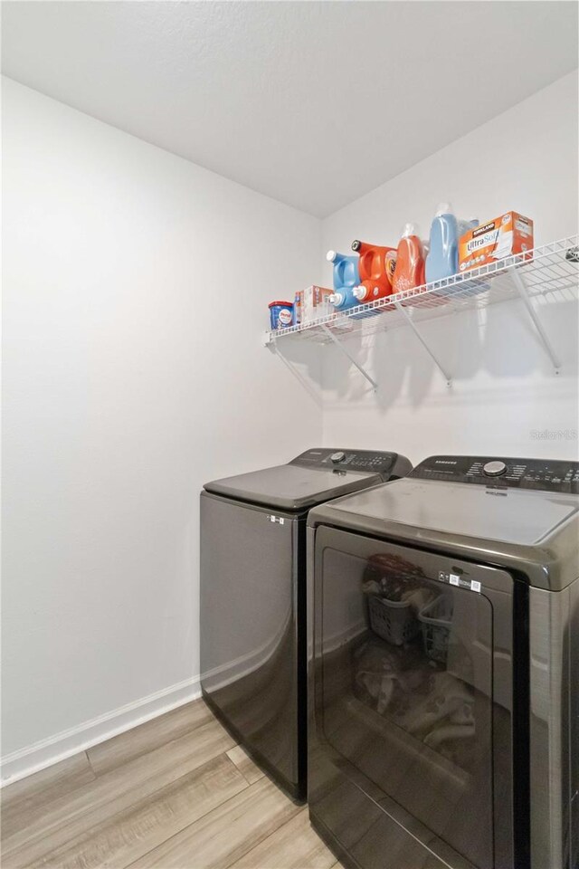 laundry area featuring light hardwood / wood-style floors and washing machine and clothes dryer