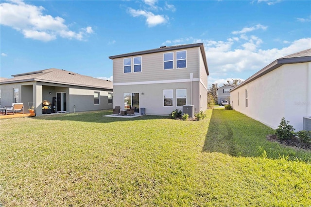 rear view of property featuring central AC unit and a yard