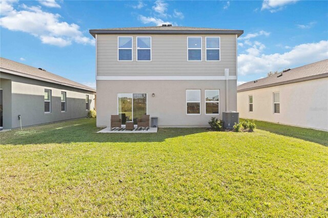 rear view of property featuring outdoor lounge area, central AC unit, a patio, and a lawn