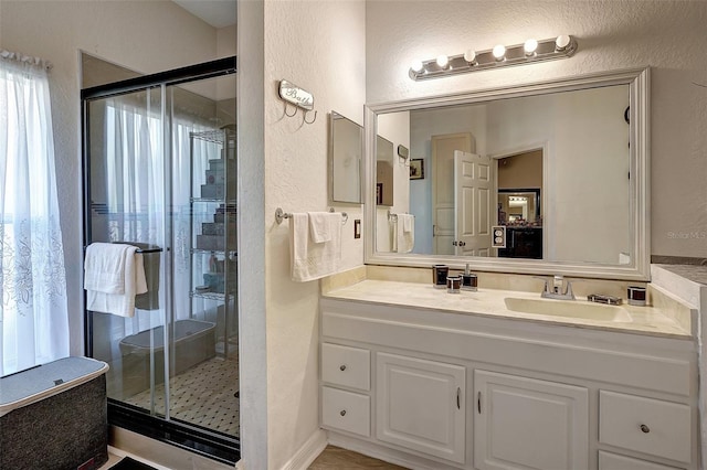 bathroom featuring vanity and a shower with door