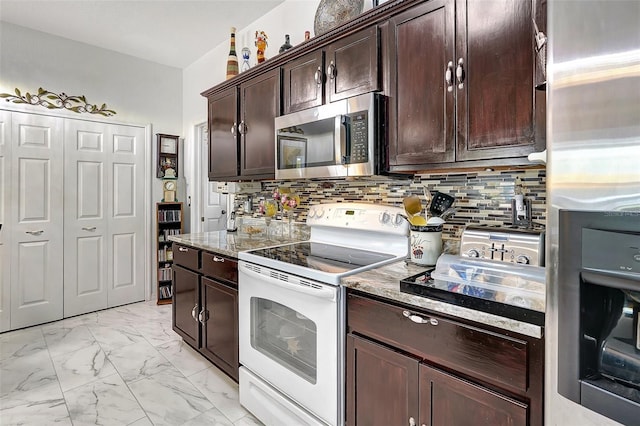 kitchen with dark brown cabinets, stainless steel appliances, light stone counters, and tasteful backsplash