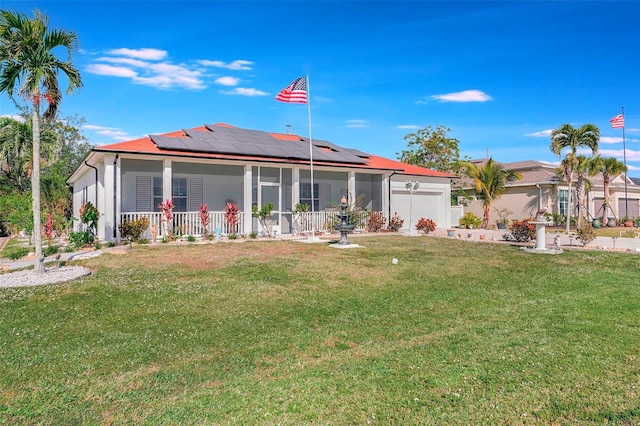 back of property featuring solar panels, a yard, covered porch, and a garage