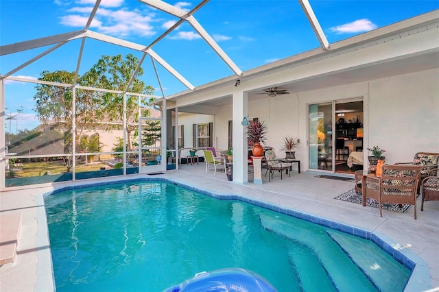 view of swimming pool featuring ceiling fan, a patio area, and glass enclosure