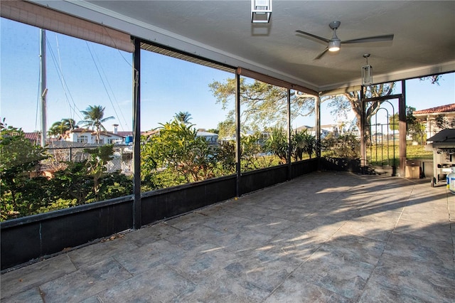 unfurnished sunroom with ceiling fan and plenty of natural light