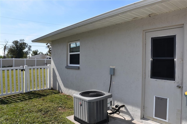 view of side of property with central AC and a yard