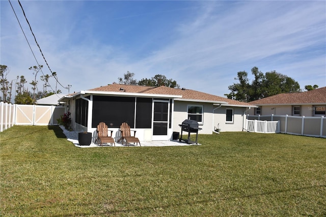 rear view of property with a patio area, a sunroom, and a lawn