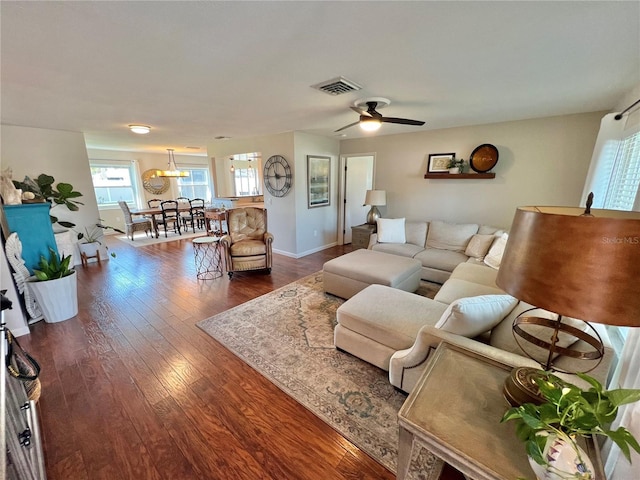 living room with dark wood-type flooring and ceiling fan