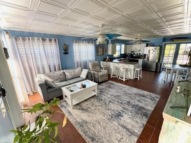 tiled living room featuring ceiling fan and a wealth of natural light